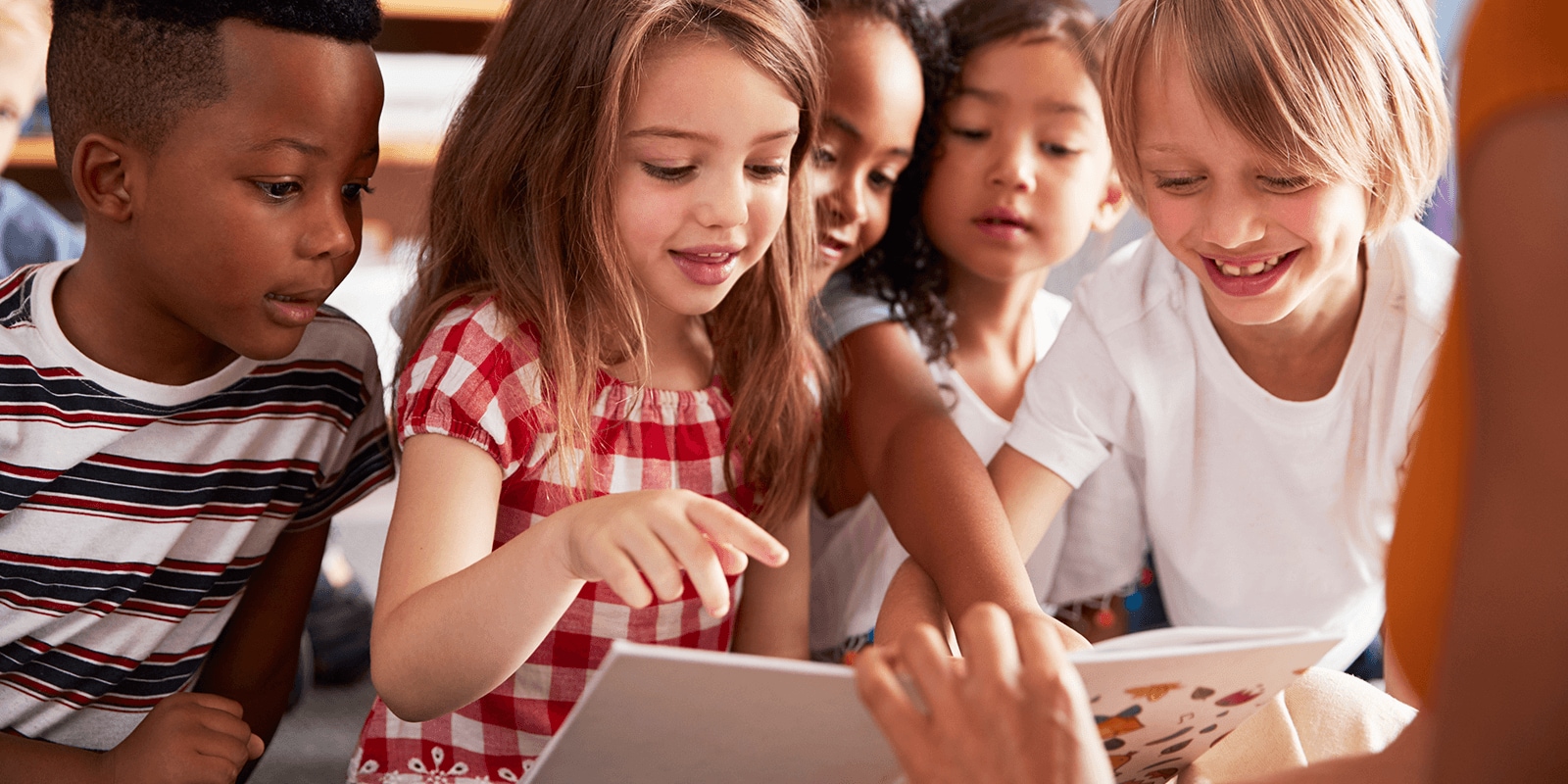 Smiling students looking at book