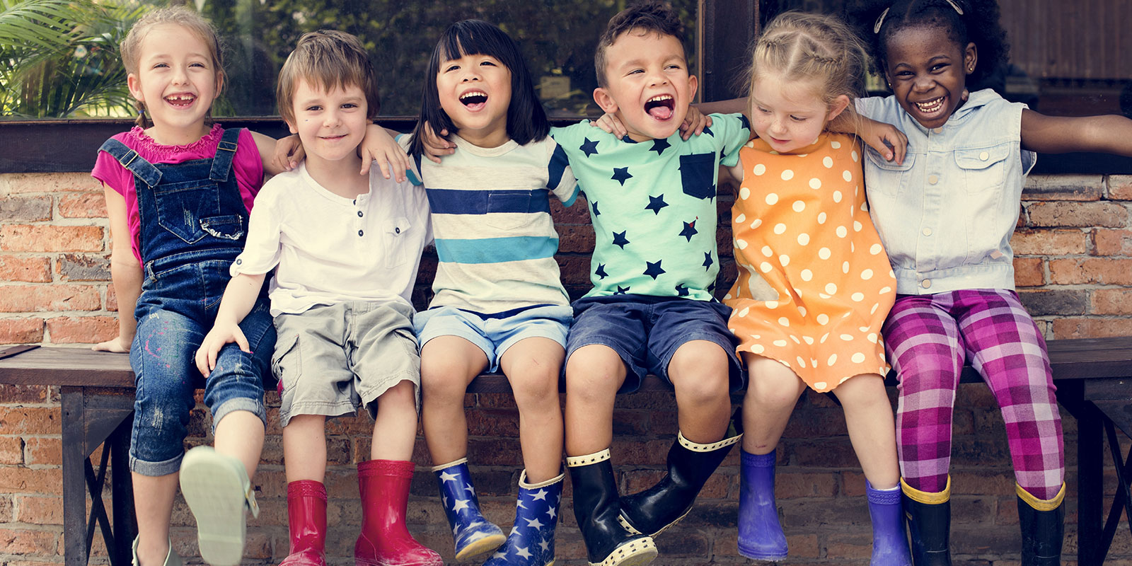 Happy, young children sitting on a bench. 