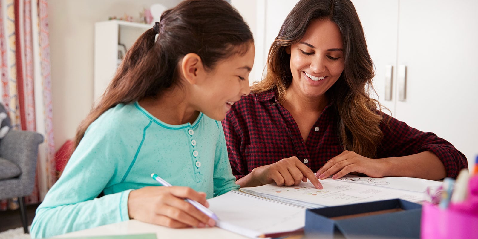 Mother helping her daughter read. 