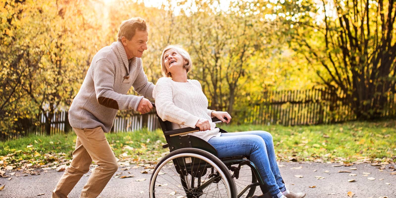 Senior couple in wheelchair in autumn nature