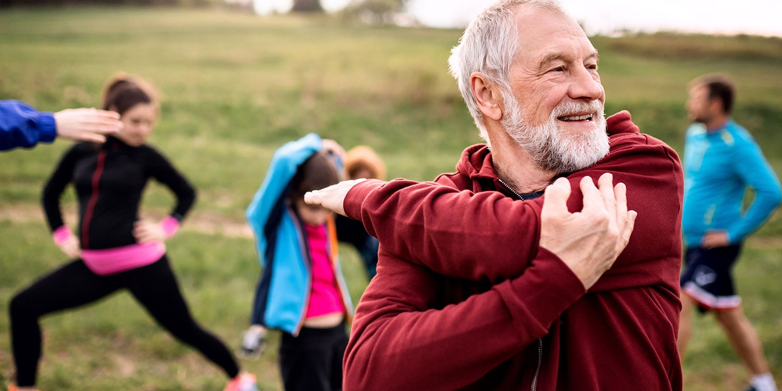 Adults warming up before doing outdoor yoga.
