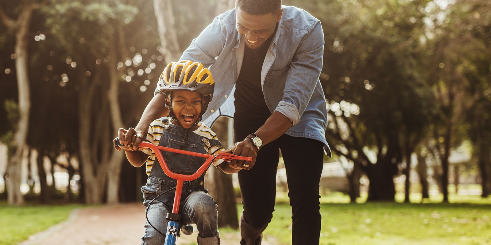 Father teaching his son how to ride a bike.