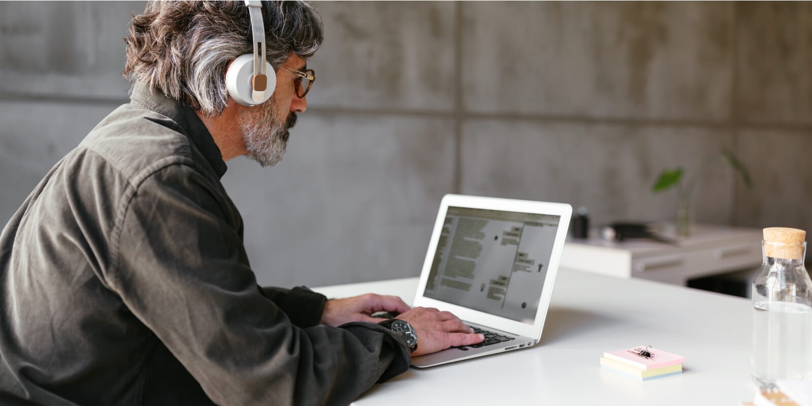 Person with headset typing on laptop