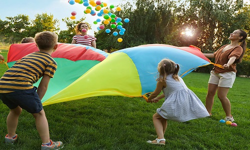 Children playing with a parachute and balloons