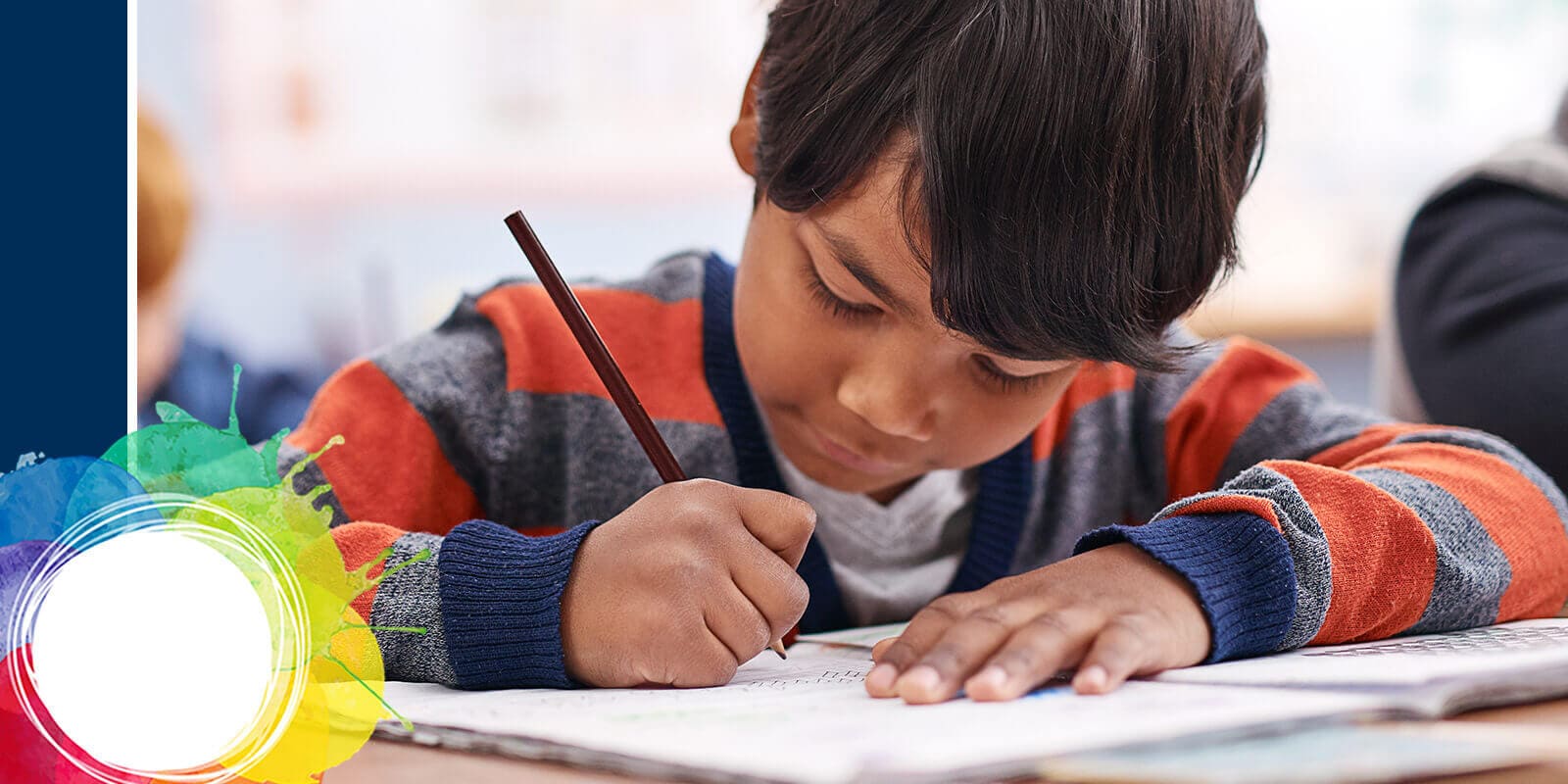 A child in a striped sweater writes in a notebook at a desk, colorful drawings visible on the left side of the image.