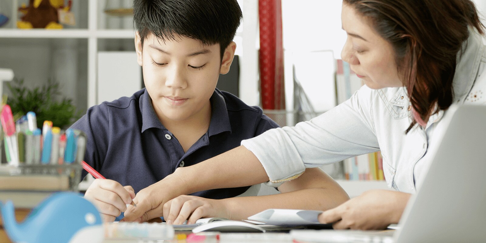 Child writing with adult assisting