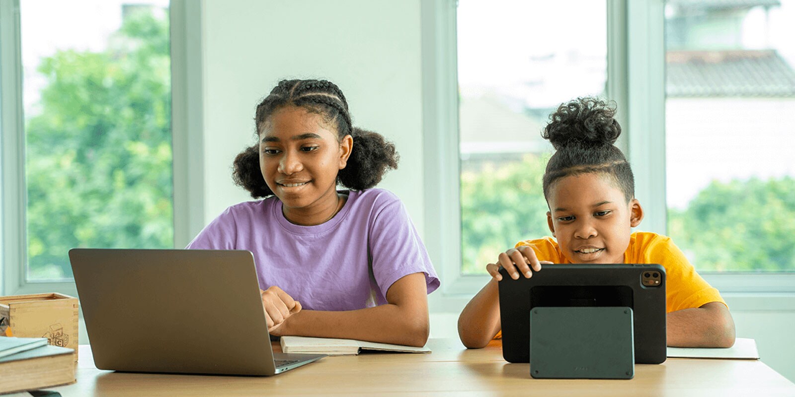 Two happy children using laptops