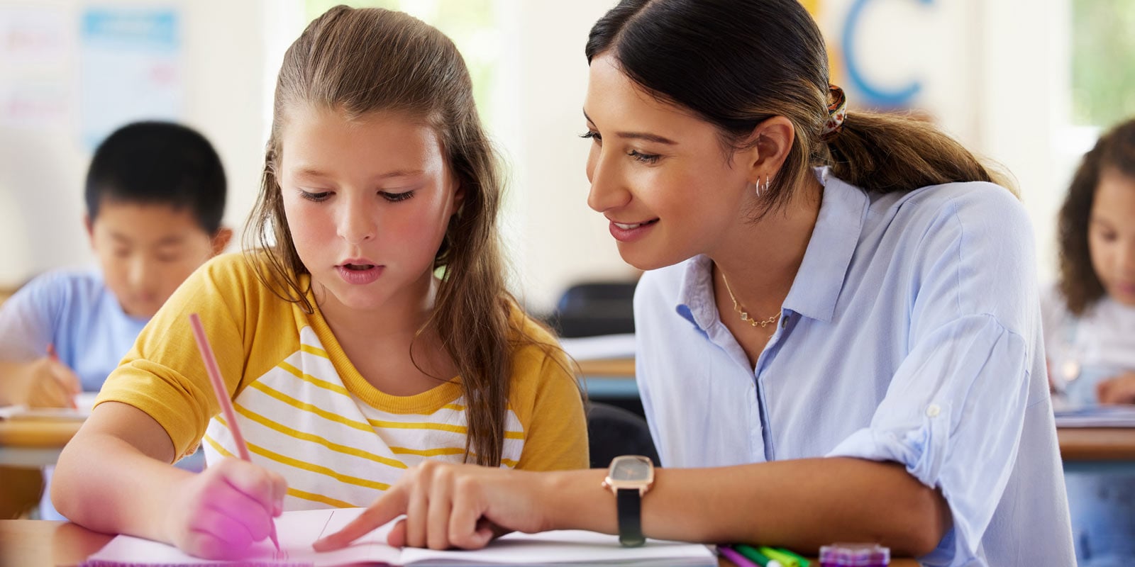 Teacher assisting young student with class work