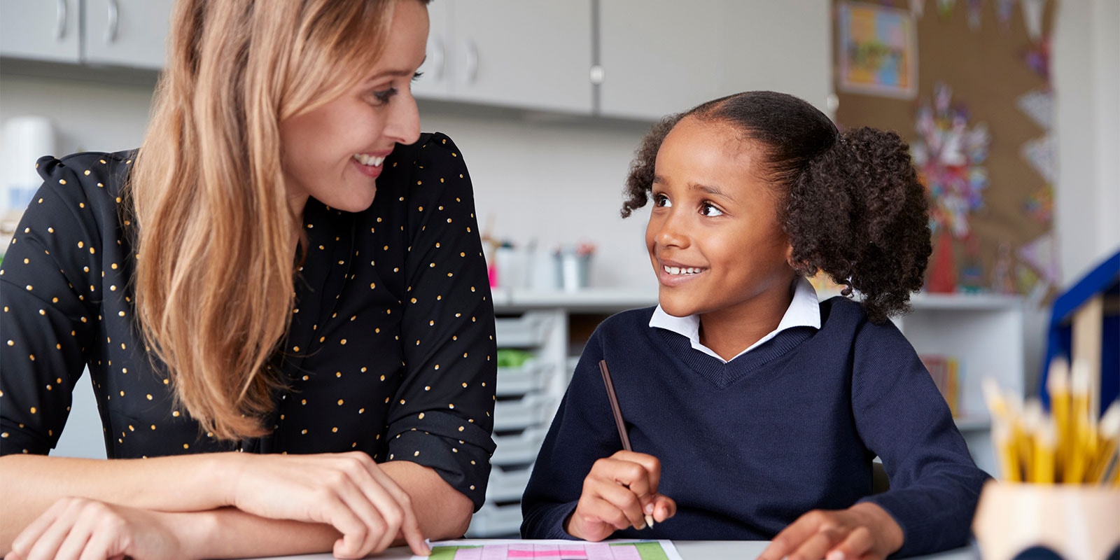Female teacher working with a young child. 