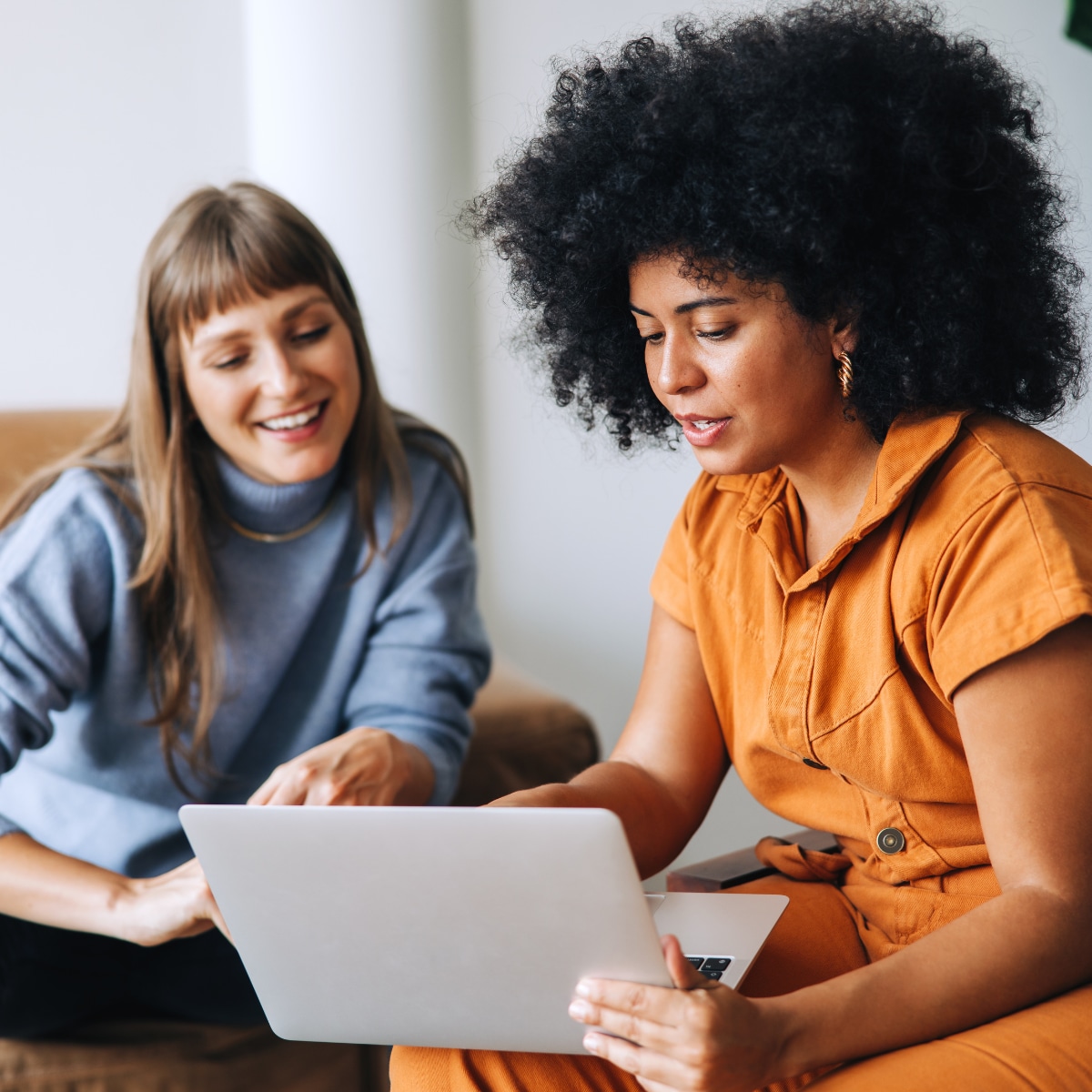 Two women working on a tablet device. 